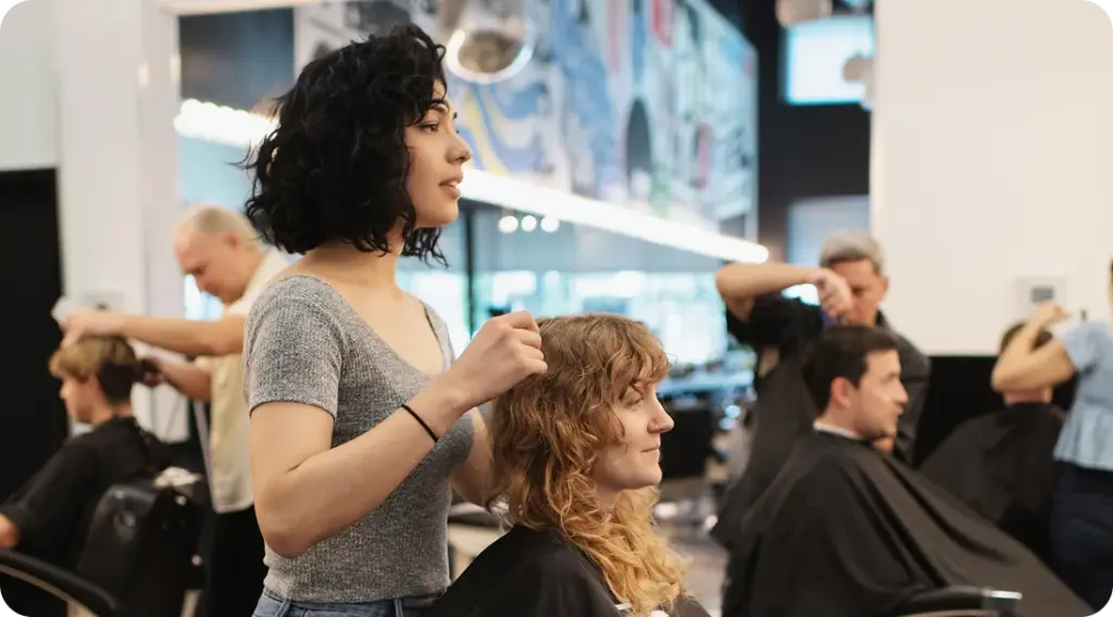 Barber giving a precision haircut to a client inside Birds Barbershop